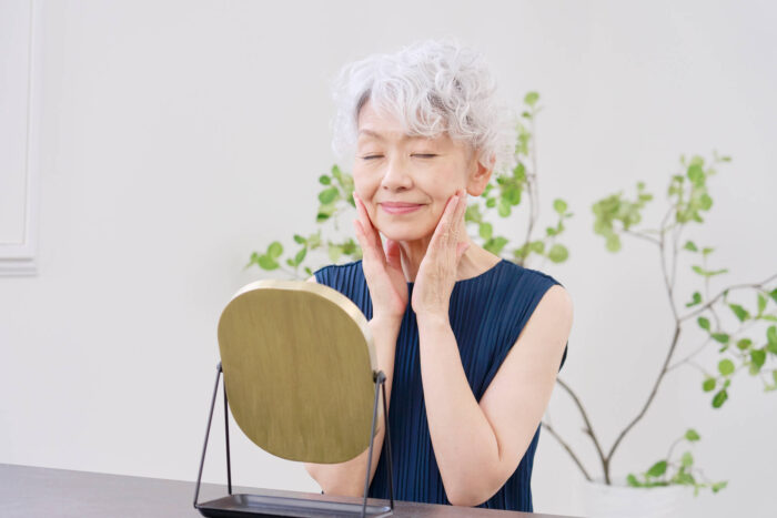 鏡を見る高齢女性