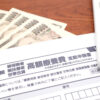 高額療養費の申請書と紙幣・電卓