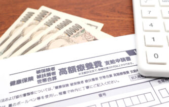 高額療養費の申請書と紙幣・電卓