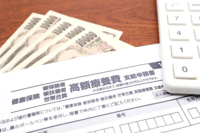 高額療養費の申請書と紙幣・電卓