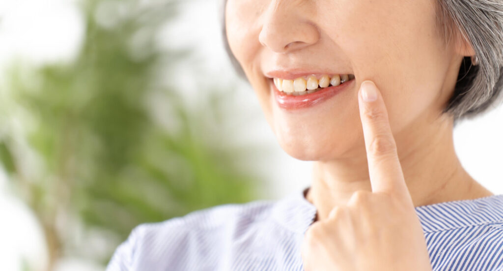 指を口元に当てて笑う人