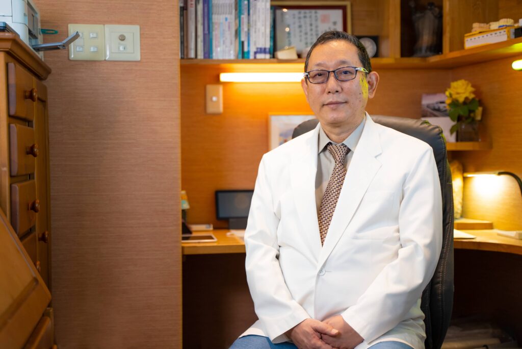 デスクの前に座る芝公園歯科の院長