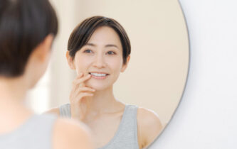 鏡の前で歯を気にする女性