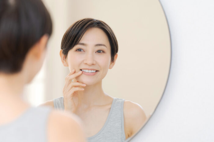 鏡の前で歯を気にする女性
